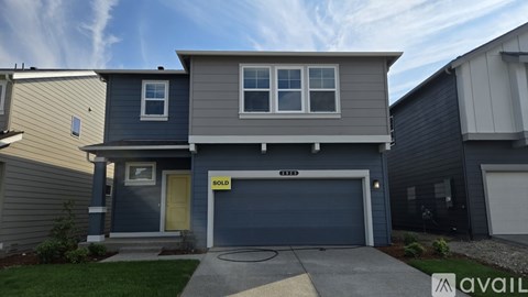 A house with a grey and blue exterior is for sale.