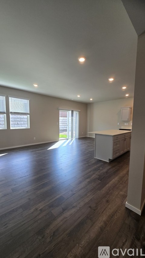 A spacious room with wooden floors and a white cabinet.