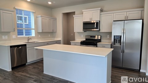A kitchen with white cabinets and a large island.