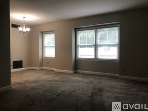 A spacious room with a large window and a chandelier.