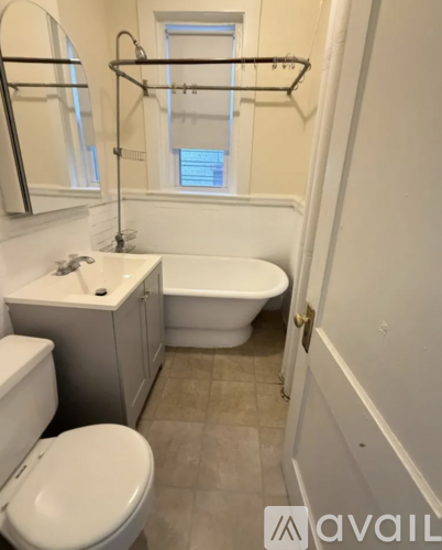 A bathroom with a toilet, sink, and bathtub.