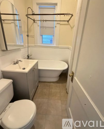 A bathroom with a toilet, sink, and bathtub.