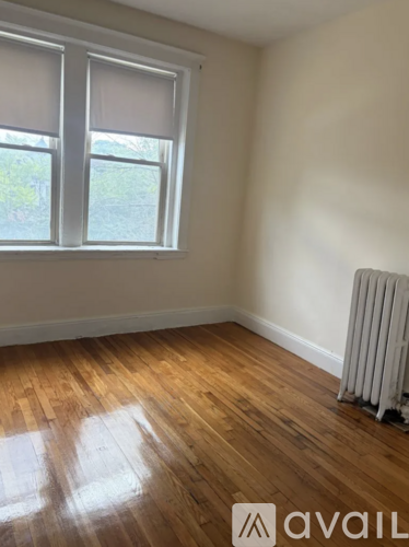 A room with a window and a radiator on the floor.