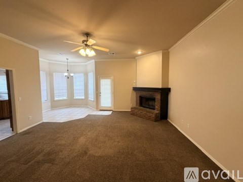 A living room with a fireplace and a ceiling fan.