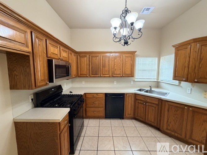 A kitchen with wooden cabinets and black appliances.