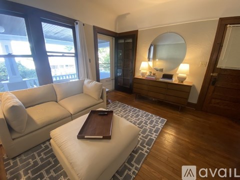 A living room with a white couch and a wooden coffee table.