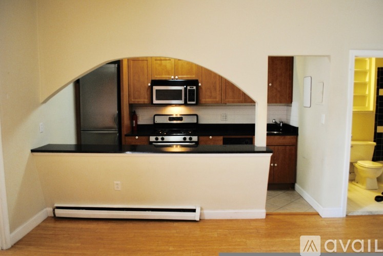 A kitchen with a black countertop and wooden cabinets.