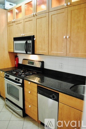A kitchen with wooden cabinets and black countertops.