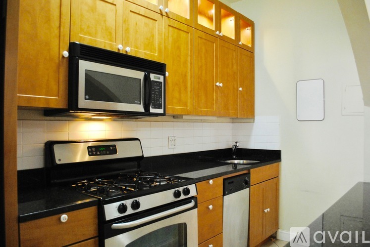 A kitchen with wooden cabinets and black countertops.