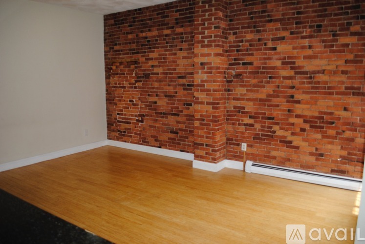 A room with a brick wall and wooden floor.