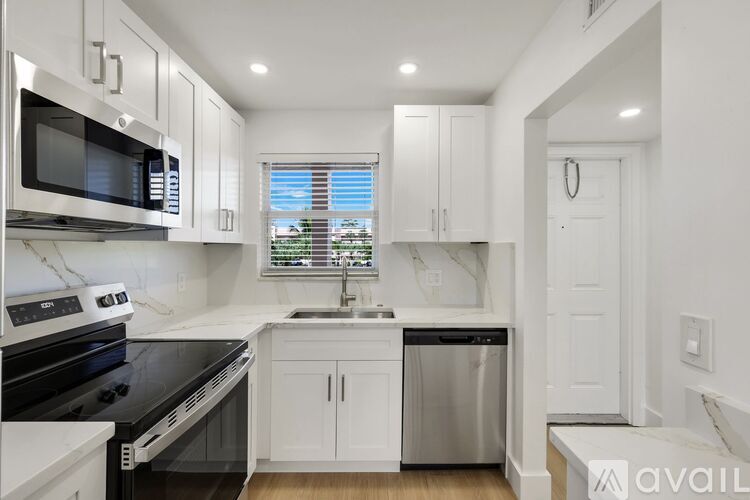 A kitchen with white cabinets and black appliances.