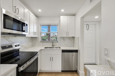 A kitchen with white cabinets and black appliances.