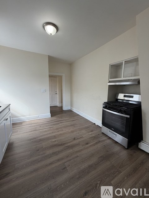 A black stove in a kitchen with a white wall and a brown box.