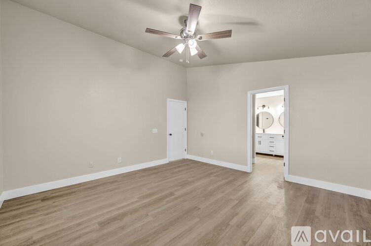 A spacious room with a ceiling fan and lighting fixture.