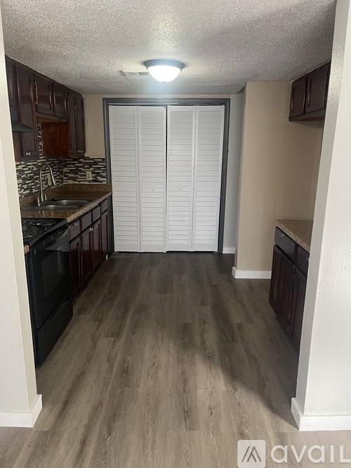 A kitchen with wooden floors and a sink.