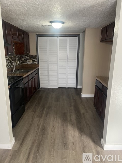 A kitchen with wooden floors and a sink.
