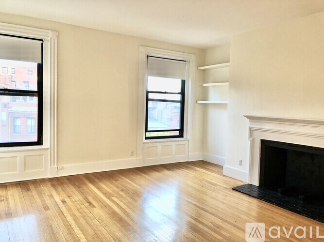 A room with a fireplace and two windows.