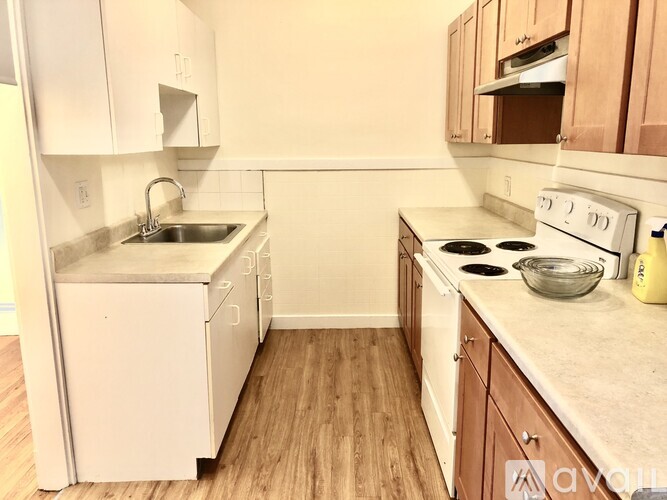A kitchen with white appliances and wooden cabinets.