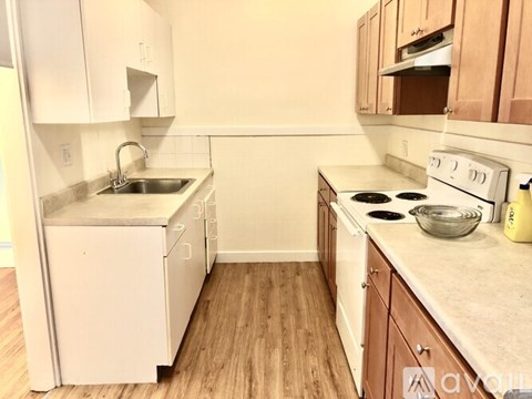 A kitchen with white appliances and wooden cabinets.
