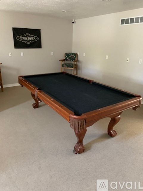 A pool table in a room with a Brunswick logo on the wall.