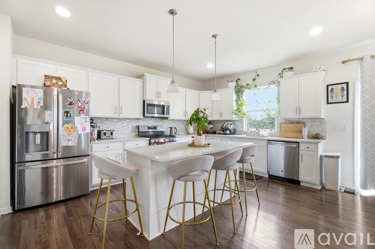 A kitchen with a white table and chairs and a refrigerator with magnets on it.