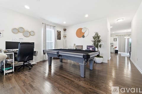 A room with a pool table and a television.