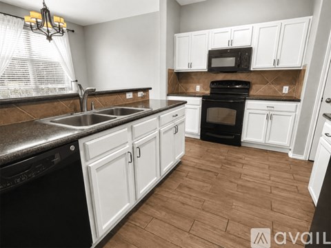 A kitchen with white cabinets and a black oven.