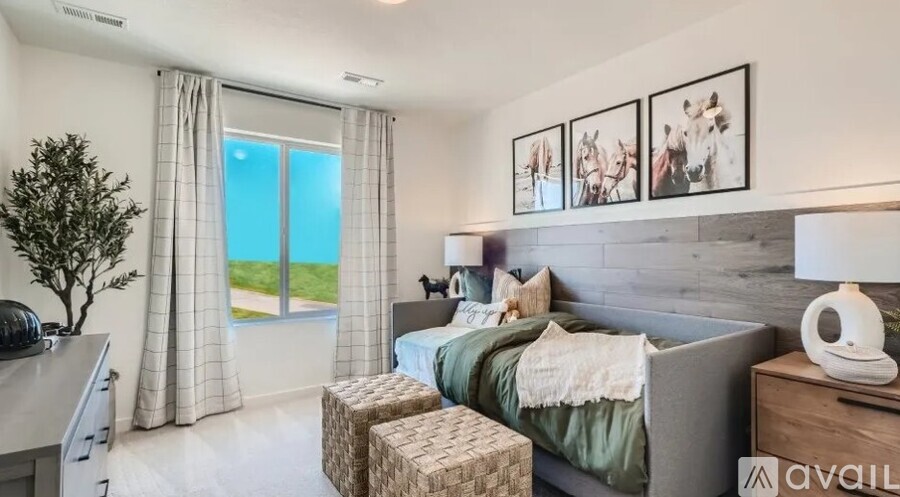 A bedroom with a bed, nightstand, and a wall with pictures.
