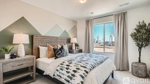 A bedroom with a large bed and a view of the city through the window.