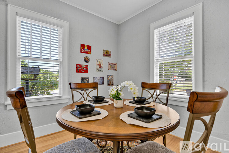 A dining room with a round table and chairs.