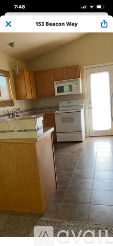 A kitchen with wooden cabinets and a white stove.
