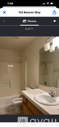 A bathroom with a toilet, sink, and mirror.