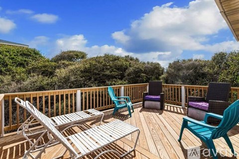 A wooden deck with chairs and a table.