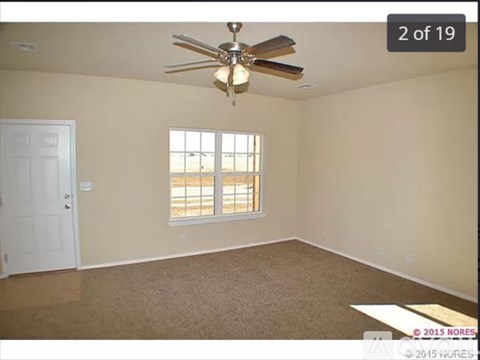 A room with a ceiling fan and a window.
