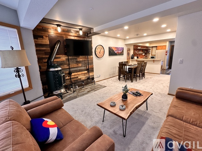 A living room with a brown couch and a wooden coffee table.
