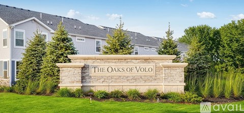 A sign that says "The Oaks of Volo" in front of some houses.
