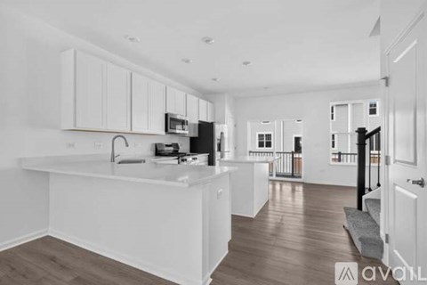 A kitchen with white cabinets and a wooden floor.