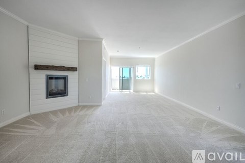 A spacious living room with a fireplace and a carpeted floor.