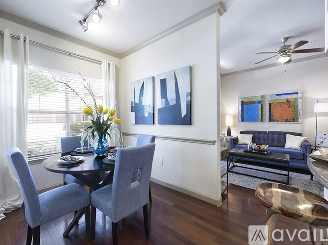 A dining room with a table set for two and a painting on the wall.