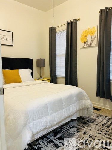A bedroom with a white bed and a yellow pillow.