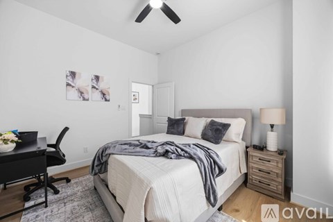 A bedroom with a bed, desk, and chair.