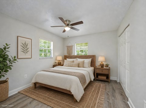 A bedroom with a large bed and a ceiling fan.