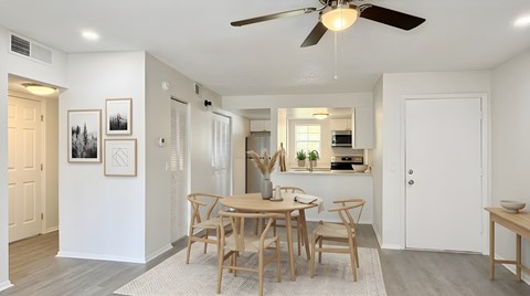 A dining room with a table set for four.