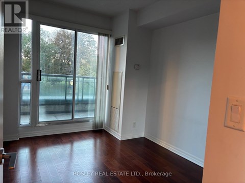 A room with a sliding glass door leading to a backyard.