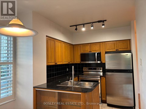 A kitchen with wooden cabinets and stainless steel appliances.