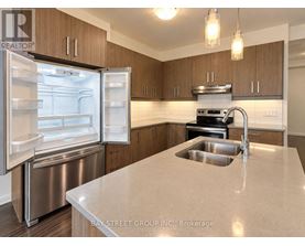 A kitchen with a refrigerator, sink, and stove.