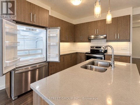 A kitchen with a refrigerator, sink, and stove.