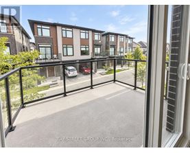 A view from a balcony of a multi-story apartment building with a car parked in the driveway.