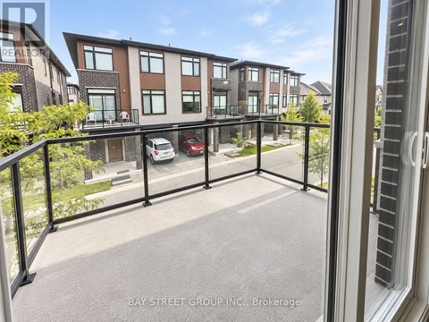 A view from a balcony of a multi-story apartment building with a car parked in the driveway.
