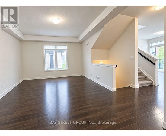 A spacious room with wooden floors and a window.
